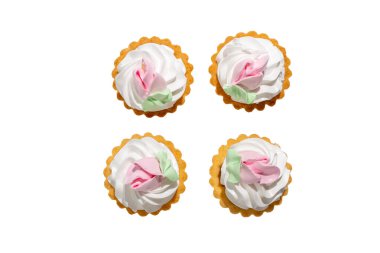 Üzerinde pembe şekerleme ve çiçekler olan dört küçük hamur işi. Bir meydanda düzenlenmişler. Beyaz arkaplanda izole edilmiş tatlı.