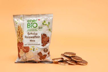 Almanya 26 Ekim 2024. Turuncu arka planda çikolatalı bir paket Ener Bio pirinç gofreti. Roketin yanında bir yığın waffle var..