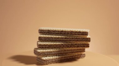 Yığılmış waffle 'lar turuncu arka planda döner. Turuncu arka planda çikolatalı waffle.