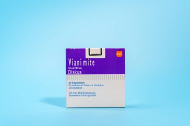 Almanya 21 Kasım 2024. Mavi arkaplanda mor astım spreyi paketi.