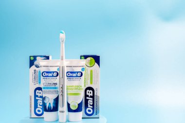 Almanya Berlin 26 Kasım 2024 Bir diş fırçası ve iki tüp diş macunu Oral-B şirketinden mavi arka planda. Diş bakımı seti.