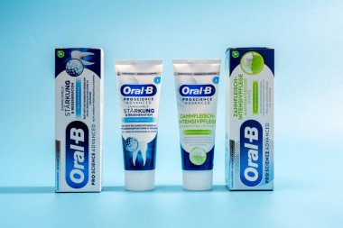 Almanya 26 Kasım 2024 İki tüp diş macunu, biri mavi, diğeri yeşil. Mavi arka planda Oral B markasından tüpler..
