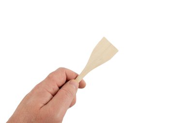 Tahta bir spatulayı tutan bir el. Spatula ince ve uzun. El onu rahat bir şekilde tutuyor.