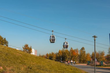26 Ekim 2024 'te Almanya' da çimenli bir tepenin üstünde iki teleferik havada asılı kaldı. Gökyüzü açık ve mavidir ve bölgede yürüyen birkaç kişi vardır. Huzurlu ve huzurlu bir sahne.