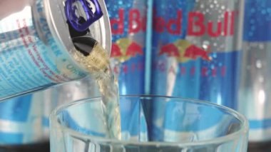 Almanya 6 Ocak 2025. Bir kutu Red Bull bardağa doldurulur. Enerji ve heyecan kavramı, içkinin kafein içeriği ve enerji takviyesi yeteneğiyle bilinir.