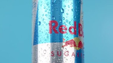 Almanya 6 Ocak 2025. Üzerinde su damlaları olan bir kutu Red Bull gösteriliyor. Kırmızı Boğa logosu mavi arka planda dönen gümüş teneke kutu. Su damlaları ferahlatıcı bir içecek izlenimi yaratıyor..