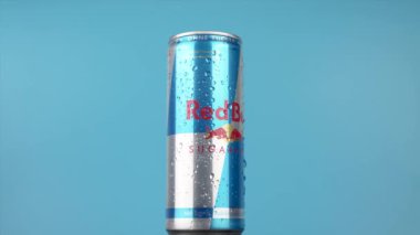 Almanya 6 Ocak 2025. Yan tarafında yoğunlaşma olan bir Red Bull konservesi mavi arka planda döner. Konserve kutusu gibi enerji ve heyecan kavramı dik duruyor ve içmeye hazır. Mavi arkaplan serinlik ekler
