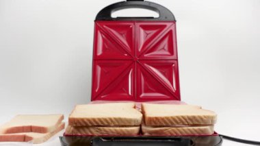 Elektrikli sandviç makinesinde işlenmiş peynirli sandviç yapmak. Sıcak kızarmış kahvaltı..