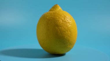 Limon mavi yüzeyde döner. Sarı renkli ve küçük bir sapı var. Limon açık değil..