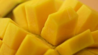 Dönen sarı mango parçası. Mangoyu küçük küplere böl..