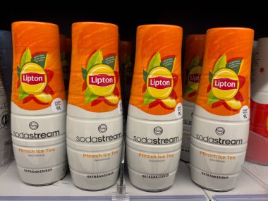 Almanya 29 Mart 2025. Dört şişe Lipton Soda Stream. Her şişe turuncu ve beyaz. Şişeler bir rafta dizilmiş.