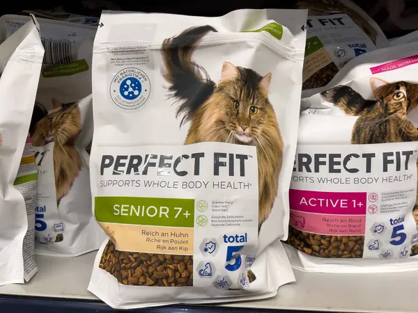 Almanya 29 Mart 2025. Bir paket kedi mamasının etiketi mükemmel uyuyor ve bir rafta. Rafta bir sürü kedi maması var. Biri kıdemli, diğeri de aktif etiketli..