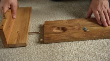 Bir adam mobilya montajı yapar. Mobilya parçaları vidayla sabitlenmiş..