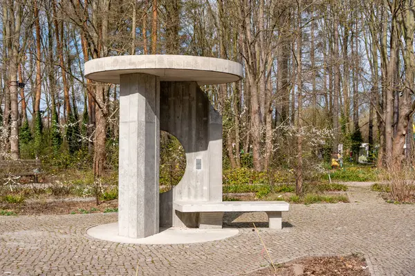 Ortasında yuvarlak bir delik olan çimento tezgahı. Deliğin sağ tarafında bir bank var.