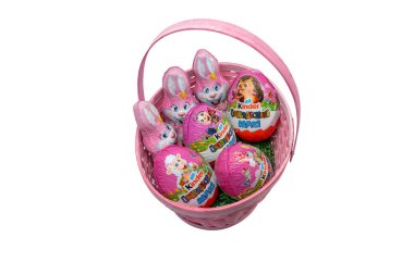 Almanya 21 Nisan 2025. Çikolatalı yumurta ve tavşanlı pembe sepet Kinder Uberraschung. Beyaz arkaplanda çikolata olan pembe hasır sepet..