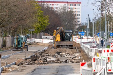 Almanya 12 Nisan 2025. İnşaat alanında yol onarım traktörleri var. İnşaat alanı çitle çevrili..