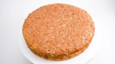 Bademli ve beyaz dolgulu yuvarlak ballı kek. Pasta beyaz arkaplanda döner.