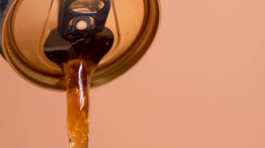 Konserve kutusundan bir soda dökülüyor. Kahverengi arka planda karbonatlı bir içecek kutusu. Konserve kutusu açık ve karbonatlı bir içecek dökülüyor..