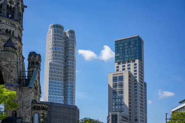 Almanya 11 Mayıs 2025. Anıt kilisesi olan modern gökdelenler. Berlin 'in modern ufuk çizgisi Kaiser Wilhelm Memorial Kilisesi' nin önü Zoofenster Waldorf Astoria ve Yukarı Batı gökdeleniyle çevrilidir..
