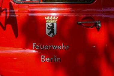 Berlin İtfaiye Departmanı eski bir arabanın üstünde. Berlin armalı, parlak kırmızı boyalı klasik itfaiye arabası. 
