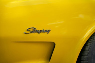 Almanya 11 Mayıs 2025. Sarı boyada Stingray harfleri var. İkonik Stingray harfleri parlak sarı boyaya mükemmel bir şekilde karşı çıkıyor. Spor gücünün ve otomotiv tarihinin açık bir sembolü..