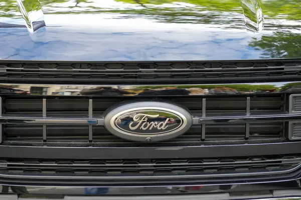 Almanya 11 Mayıs 2025. Siyah renkli Ford Grill. İkonik oval logolu parlak siyah bir Ford ızgaranın önü. Çevrenin yansımaları arabanın parlak yüzeyini vurgular