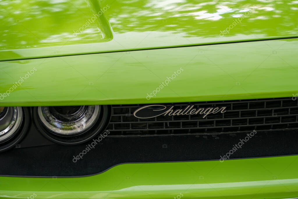 Germany Berlin May 11, 2025. Challenger lettering on the front. Macro shot of Challenger logo and headlights on green muscle car - modern retro style.