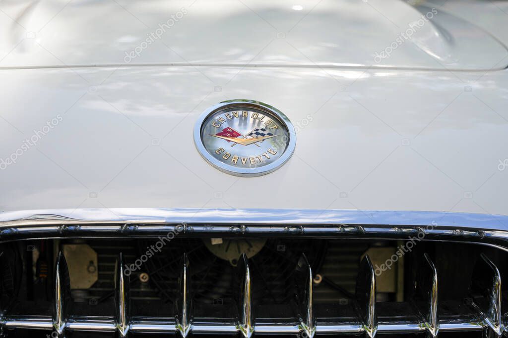 Germany Berlin May 11, 2025. Chevrolet Corvette Emblem - Close-up. Close-up of the classic Corvette emblem with racing flags on white paint. The shiny logo embodies speed, power, and American automotive icons.