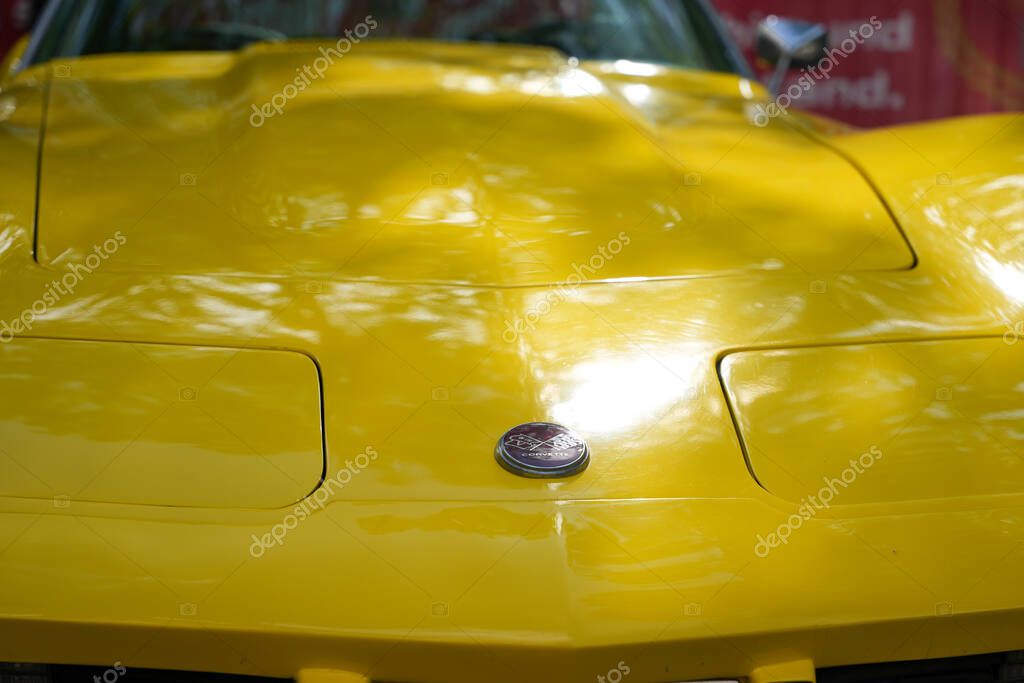 Germany Berlin May 11, 2025. Corvette Close-up of hood with emblem. The bright yellow hood of a Corvette gleams in the sunlight. In the center is the classic emblem with crossed flags, a symbol of strength and elegance.