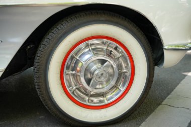 Almanya 11 Mayıs 2025. Krom tekerlekli Goodyear Whitewall lastiği. Zarif bir Goodyear beyaz duvar lastiği, kırmızı kenarlı ve parlak krom kapaklı. Amerikan arabalarının altın çağından klasik bir lastik tasarımı..