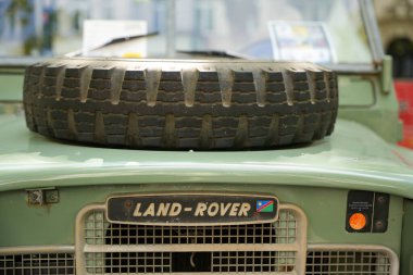 Almanya 11 Mayıs 2025. Yedek lastiği olan bir arazi aracı. Kaputunda yedek lastiği olan haşin bir Land Rover. Bir bayrak ve kederli bir bakışla ön kalkan Maceracı bir yetenek ekler..