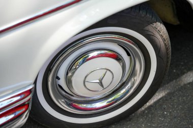 Almanya 11 Mayıs 2025. Mercedes Whitewall Lastikleri. Klasik çizgilerle çerçevelenmiş beyaz lastikli parlak bir Mercedes jant kapağı. Lüks sedanların çağından zarif bir ayrıntı..