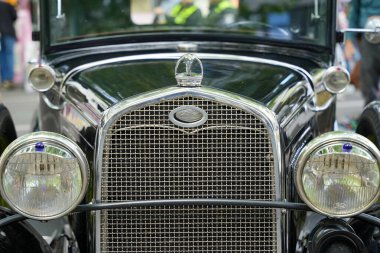 Almanya 11 Mayıs 2025. Klasik Ford Car Front. Pırıl pırıl bir ızgarası ve yuvarlak farları olan klasik bir Ford arabanın ön tarafında. Klasik Ford amblemi nostaljik estetiğin odak noktasıdır..