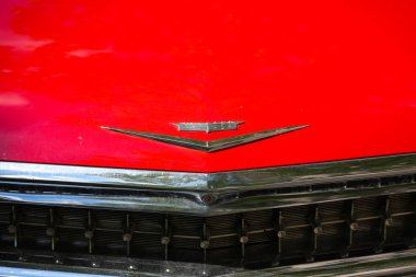Almanya 11 Mayıs 2025. Logolu Cadillac kaputu. Klasik Cadillac amblemi şık klasik bir arabanın kırmızı kaputunda duruyor. Parlak yüzey ışığı büyüleyici bir şekilde yansıtıyor..