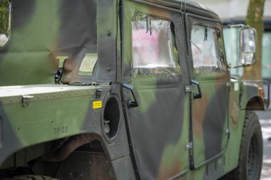 Almanya 11 Mayıs 2025. Kamufle edilmiş askeri araç. Kamuflaj boyası ve sağlam bir vücudu olan askeri bir araç. Mat yüzeyler ve plastik pencereler işlevsel off-road kapasitesini gösteriyor.
