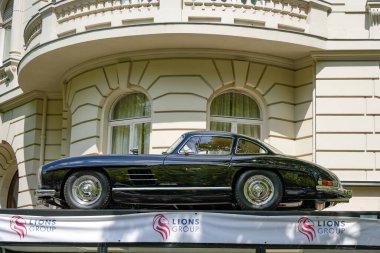 Almanya 11 Mayıs 2025. Mercedes 300 SL Gullwing. Klasik siyah bir Mercedes 300 SL, muhteşem bir binanın önünde bir platformda sergileniyor. Efsanevi martı kanadı lüks ve otomotiv tarihini temsil eder..