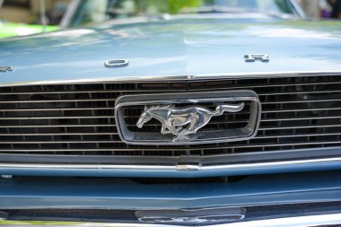 Almanya 11 Mayıs 2025. Izgarasında logo olan Mustang. Klasik bir Ford Mustang 'in önünde ünlü at logosu var. Araba güç, tarz ve ikonik statü yayıyor..