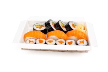 Suşi karışımı beyaz arka planda, paket kutusunun önü görünüyor. Somon, pirinç, avokado ve Norveç çarşafı ile birlikte beyaz paket servis kutusunda taze hazırlanmış suşi. Paket servis için mükemmel. Beyaz arkaplanda suşi kompozisyonu.