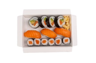 Yukarıdan çekilmiş bir kutuda suşi. Somon, avokado ve zencefilli suşi kutusunun üst görüntüsü temiz. Teslimat servisi ya da menü için mükemmel bir sunum. Beyaz arkaplanda suşi kompozisyonu.