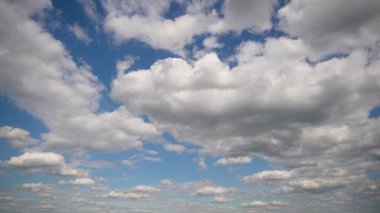 Beyaz bulutlu güzel gökyüzünün zamanı. Parlak mavi gökyüzü büyük kabarık beyaz bulutlarla benekli. Huzurlu bir sahne ve seni rüya görmeye davet ediyor..