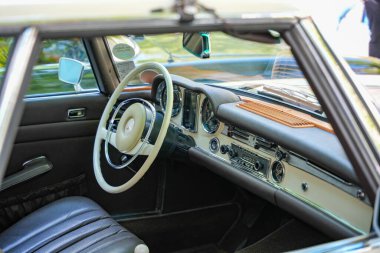 Almanya 11 Mayıs 2025. Mercedes-Benz iç mimari klasiği. Parlak direksiyonu, krom detayları ve iyi korunmuş gösterge paneli olan klasik bir Mercedes 'in iç görünüşü. Saf stil otomotiv kültürü.