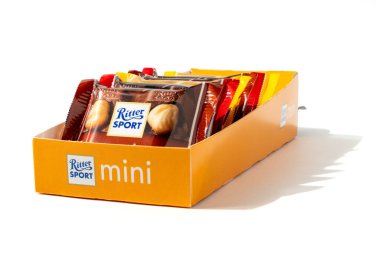 Renkli bir mini Ritter spor kutusu bir açıdan çekilmiş. Açık ambalajdan farklı renklerde küçük çikolatalar. Beyaz arkaplanda izole edilmiş çikolata çubukları.