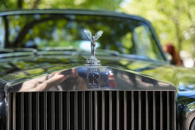 RollsRoyce amblem kaput süsü, ön manzara. Ecstasy kapüşonunun ikonik ruhu görkemli bir şekilde Rolls Royce ızgarasının üzerinde duruyor. Lüks ve prestij her krom detayına yansıyor..