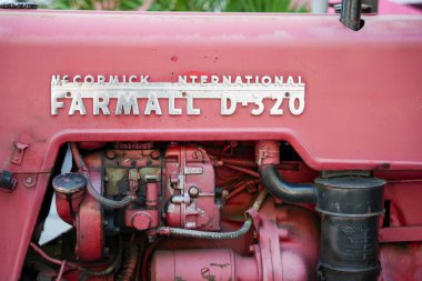 Farmall D-320 Detay. Bu detaylı çekim Farmall D-320 traktörünün görünür teknolojiye sahip ayırt edici modelini gösteriyor. Yüzey aşınma ve yırtılma ile karakterize edilir..