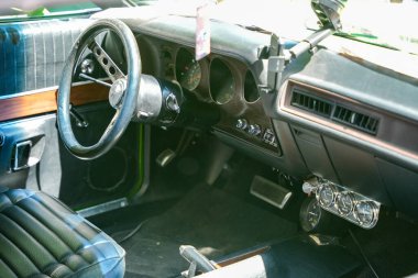 Almanya 11 Mayıs 2025. İçi siyah ek göstergelerle dolu. İçi siyah deri kaplı, kaslı bir arabanın gösterge panelinin altında ek göstergeler ve spor direksiyon simidi var. Tarzı güçlü araçları anımsatıyor.