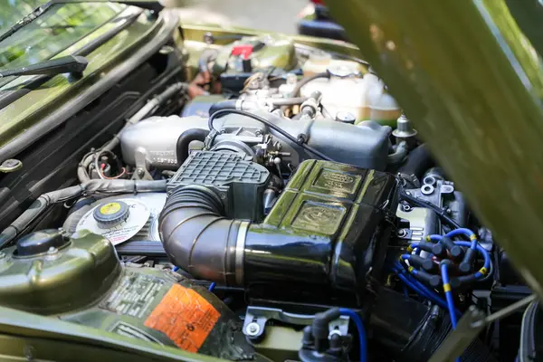 Almanya 11 Mayıs 2025. Yeşil boyalı klasik bir araba motoru kompartımanı. Görünür bileşenleriyle açık motor bölmesi ve yeşil boyalı vücut parçaları teknoloji meraklıları paralarının karşılığını burada alacaklar. Kablolar ve hava filtresi çok açık.
