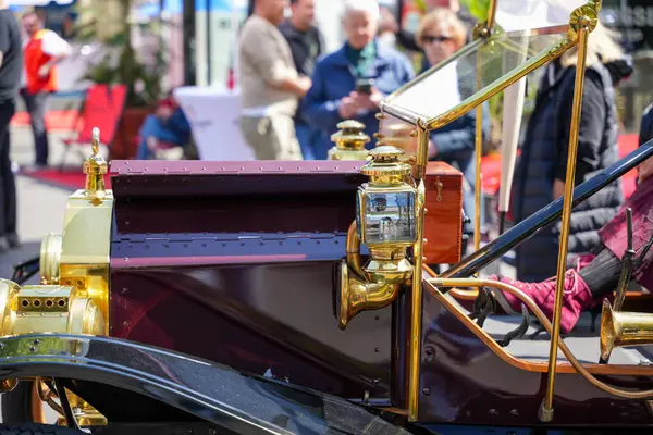 Almanya 11 Mayıs 2025. Pirinç fenerli antika bir aracın yan görüntüsü. Parlak pirinç detayları ve antika cazibesi olan tarihi bir aracın yan görüntüsü. Arka plandaki kişiler sergi bağlamını vurguladılar.