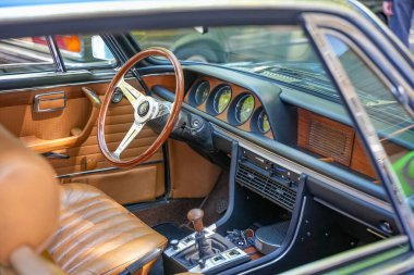 Almanya 11 Mayıs 2025. Vites kolu ve yuvarlak enstrümanlarla. Klasik bir vites kolu, yuvarlak enstrümanlar ve 70 'lerin tarzında ahşap elementler. Deri kaplı koltuklar yüksek kaliteli görünümün altını çiziyor.