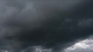 Kara fırtına bulutları hareket ediyor. Şiddetli, karanlık fırtına bulutları hızla şekillenir ve dramatik bir zaman döngüsü içinde kıvrılır. Gökyüzü giderek kötüleşerek yaklaşan havanın güçlü bir görüntüsünü oluşturuyor..