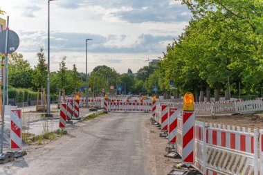 Şehir caddesi boyunca sayısız uyarı bariyeri ve tabelaları olan yol yapım bölgesi. Yol trafiğe kapalı..